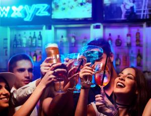 a group of people holding up wine glasses in a bar at Aloft Cancun in Cancún