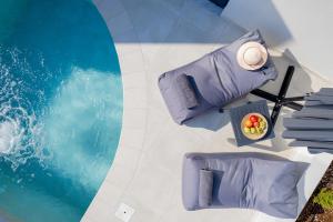 - une vue sur la piscine avec des oreillers violets dans l'établissement White Cliff Luxury Suites by A&D Properties, à Pórto Ráfti
