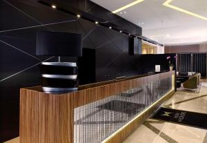 a lobby with a reception desk with a black wall at DoubleTree by Hilton Oradea in Oradea