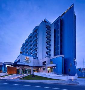 a hotel with a blue building in front of a street at DoubleTree by Hilton Oradea in Oradea