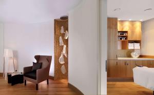 uma sala de estar com uma cadeira e uma mesa em DoubleTree by Hilton Oradea em Oradea