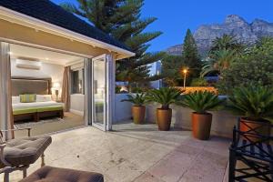 a patio with a bed and some plants at Vetho Villa in Cape Town
