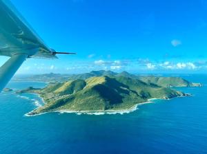an island in the ocean viewed from an airplane at VILLA PELICAN in Oyster Pond