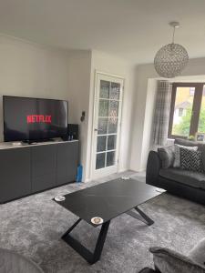 - un salon avec une télévision et une table basse dans l'établissement Home away from home, à Peterborough