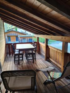 een houten terras met een tafel en stoelen bij Gemütliches Chalet in Innertkirchen