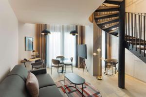 a living room with a couch and a table and chairs at Canopy By Hilton Paris Eiffel Tower in Paris
