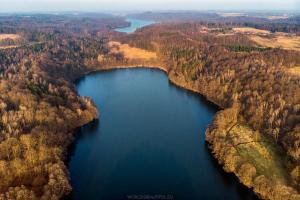 an aerial view of a lake in a forest at Lawendowy Wypas in Mierzeszyn