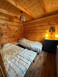 a room with two beds in a log cabin at Lawendowy Wypas in Mierzeszyn