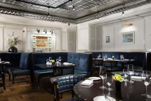 a dining room with tables and blue chairs and tablesktop at Hilton Prague Old Town in Prague