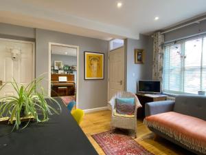 a living room with a couch and a tv at Artist's eclectic Town House close to river in Woodbridge