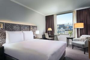 um quarto de hotel com uma cama branca e uma janela em Hilton Prague Old Town em Praga
