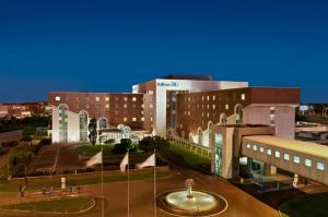 a large building with a courtyard in front of it at Hilton Rome Airport in Fiumicino