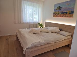 維也納的住宿－Balcony Oasis Wilhelminenberg，卧室内的一张床铺,墙上有绘画作品