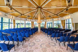 Cette grande chambre est dotée de chaises bleues et d'un grand plafond. dans l'établissement DoubleTree by Hilton Royal Parc Soestduinen, à Soestduinen