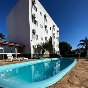 a hotel with a swimming pool in front of a building at Hotel Boituva Inn - Your Hotel in Boituva