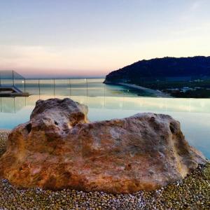 uma rocha sentada na margem de uma piscina de água em Hotel Residence Il Porto em Mattinata