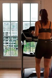 a woman standing in front of a bed looking out a window at Scala Hotel Buenos Aires in Buenos Aires