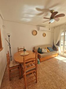 - un salon avec une table et un canapé dans l'établissement Casa Margarita, à Torrevieja