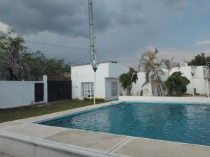 een zwembad voor een wit huis bij Quinta primaveras in Cuernavaca
