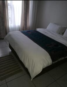 a large bed in a bedroom with a window at Sagewood Manor in Midrand
