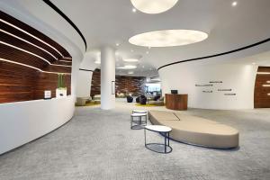 an office lobby with a bench and tables at DoubleTree by Hilton Wroclaw in Wrocław