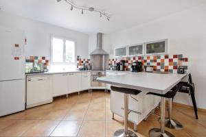 a kitchen with white cabinets and a table in it at Lovely house with garden Saint-Cloud near Paris - Welkeys in Saint-Cloud