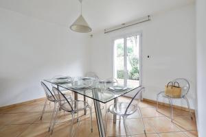 a dining room with a glass table and chairs at Lovely house with garden Saint-Cloud near Paris - Welkeys in Saint-Cloud