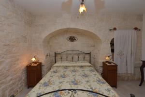 una camera con un grande letto e due comodini di Masseria Pentima Vetrana Resort ad Alberobello
