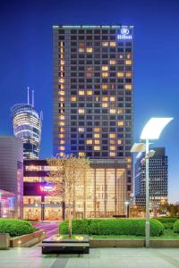 a tall building in a city at night at Hilton Warsaw City Hotel in Warsaw