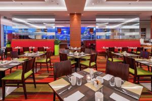 a restaurant with tables and chairs in a room at Hilton Warsaw City Hotel in Warsaw