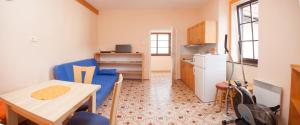 a small room with a table and a kitchen at Apartma na Starem Placu in Idrija