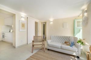 a living room with a white couch and a chair at Gardenland House Leiria in Leiria