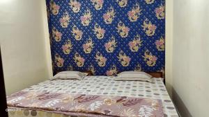 Ce lit se trouve dans un dortoir doté d'un mur bleu. dans l'établissement Shree Shivaay Guest House, à Ujjain