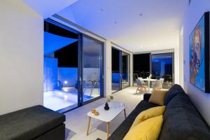 sala de estar con sofá y mesa en White Cliff Luxury Suites by A&D Properties, en Porto Rafti