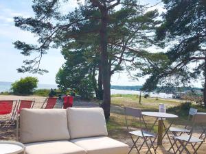 a couch and chairs and a table and a tree at Holiday home SÖLVESBORG X in Sölvesborg