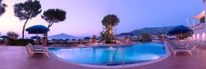 a large swimming pool with chairs and umbrellas at a resort at Hilton Sorrento Palace in Sorrento