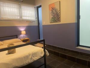 - une chambre avec 2 lits superposés et une fenêtre dans l'établissement El Machico Hostel, à Panama City