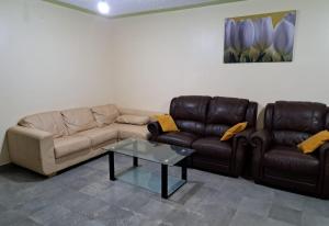 a living room with two couches and a coffee table at Mfalme House, Ngoingwa Estate, 100 Metres from Thika-Mangu Rd, Close to Thika City Centre - Free Parking, Fast Wi-Fi, Smart TV, 2 Bedrooms Perfect for a Family of 2-4 Members in Thika