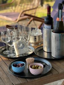 Nisaki Mathraki B&B في مدينة كورفو: طاولة خشبية مع كؤوس للنبيذ وزجاجات للنبيذ