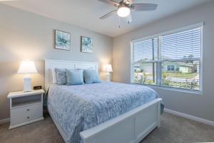 1 dormitorio con 1 cama con edredón azul y ventana en Coastal Harmony en Foley