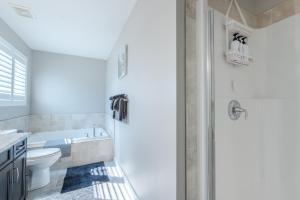 y baño con bañera, aseo y lavamanos. en Modern 3 Bedroom Home & Office & Media Room en Cochrane