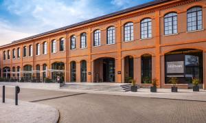 a large orange building with a lot of windows at Hilton Lake Como in Como