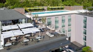 an aerial view of a rooftop patio with white umbrellas at Hilton Lake Como in Como