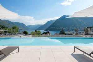 a swimming pool with a view of a lake and mountains at Hilton Lake Como in Como