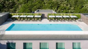 an overhead view of a pool with chairs and umbrellas at Hilton Lake Como in Como