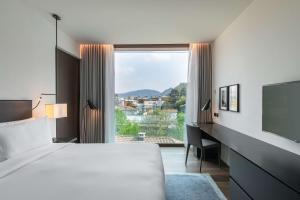 a hotel room with a bed and a large window at Hilton Lake Como in Como