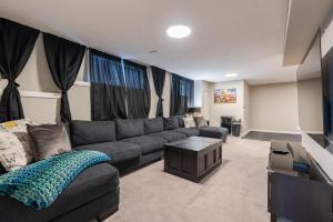 salon z kanapą i telewizorem w obiekcie Modern 3 Bedroom Home & Office & Media Room w mieście Cochrane