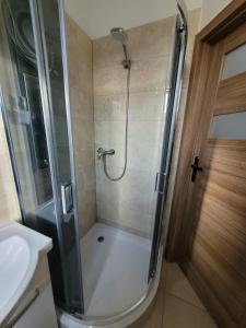 a bathroom with a shower with a glass door at Przy Bulwarze in Mielno