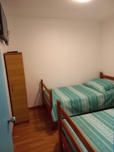 1 dormitorio con 2 camas y vestidor en HOSTAL BAQUEDANO IQUIQUE, en Iquique