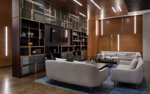 a living room with two couches and a tv at DoubleTree By Hilton Moscow - Vnukovo Airport Hotel in Vnukovo